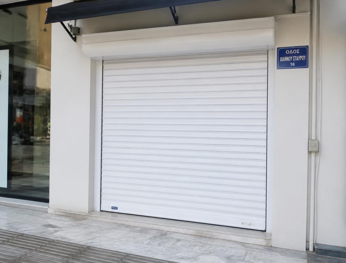 Λευκό αλουμινένιο ρολό ασφαλείας σε βιτρίνα καταστήματος